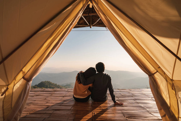 Young couple traveler looking beautiful landscape at sunset and camping on mountain, Adventure travel lifestyle concept - Photo, image