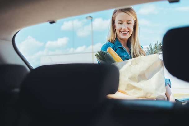 young woman with shopping bag on street. View from car windshield - Photo, image