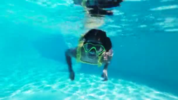 Menina nada debaixo d 'água em uma máscara panorâmica subaquática. Uma criança snorkels. Bolhas cercam o bebê em todos os lados. - Filmagem, Vídeo