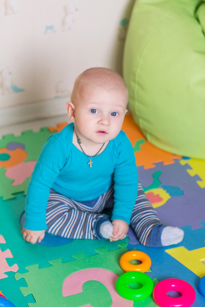 Cute little baby playing with colorful toys indoors - Foto, Imagen