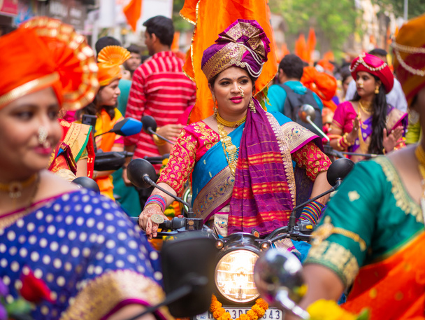 Mumbai, India - April 02, 2022: A beautiful indian female dressed in traditional attire driving a bike during a procession celebrating Gudhi Padva or Hindu new year in Mumbai - Fotó, kép