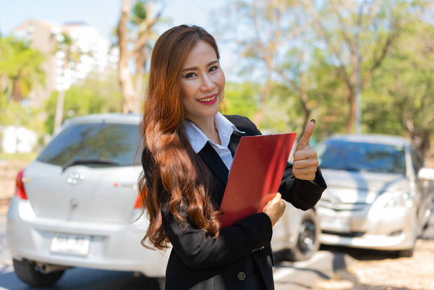 Aziatische vrouwen zijn verzekeringsagenten houden klemborden en staan in de voorkant van auto-ongevallen na het controleren van auto-schade, concepten van de verzekering, en auto-ongevallen. - Foto, afbeelding
