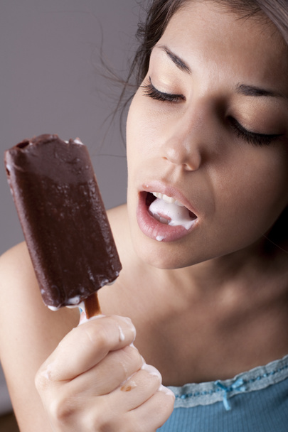 チョコレート アイス クリームを舐めているセクシーなブルネットの女性 - 写真・画像
