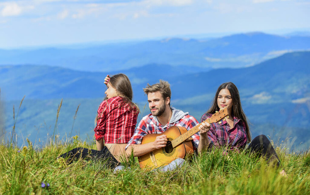 Outdoor adventure. hiking adventure. happy men and girls friends with guitar. friendship. romantic picnic in tourism camp. campfire songs. group of people spend free time together. family camping - Фото, изображение