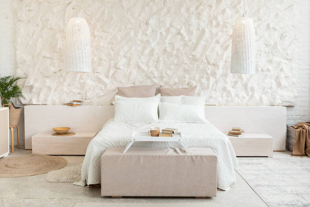 Kodikas sänky modernissa makuuhuoneessa, jossa on valkoiset seinät ja huonekalut - Valokuva, kuva