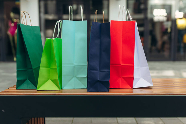Värikkäitä paperisia ostoskasseja kadulla. shopaholainen henkilö ostoskeskuksessa - Valokuva, kuva