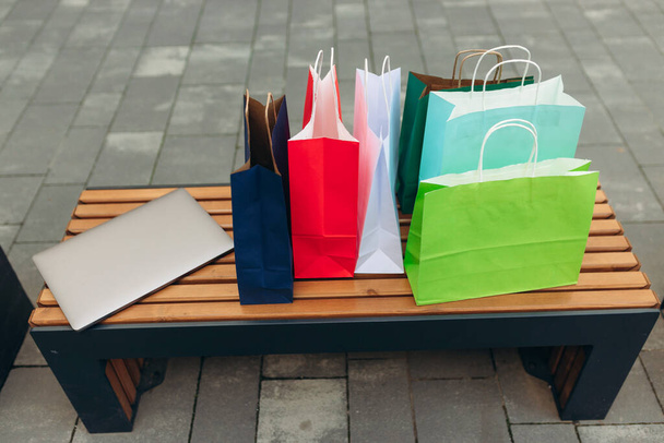 Laptop ve alışveriş torbaları alışveriş merkezinde. Çevrimiçi alışveriş kavramı - Fotoğraf, Görsel
