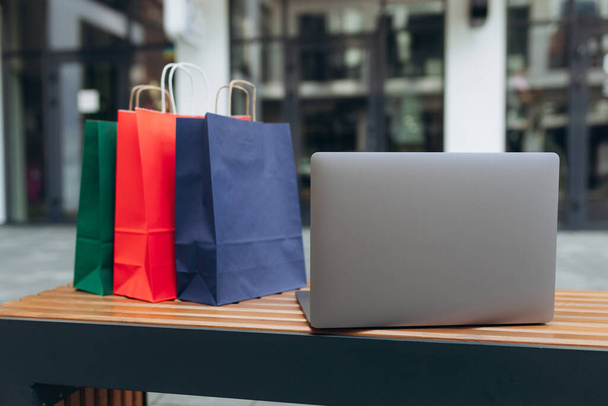 Laptop e sacos de compras no shopping. Conceito de compras online - Foto, Imagem