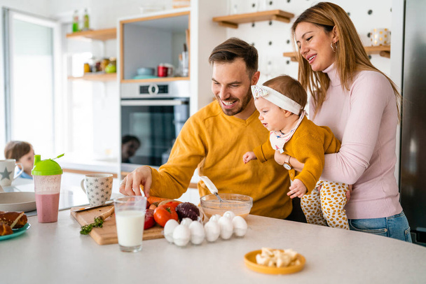 Happy family in the kitchen having fun and cooking together. Healthy food at home. - Foto, Bild