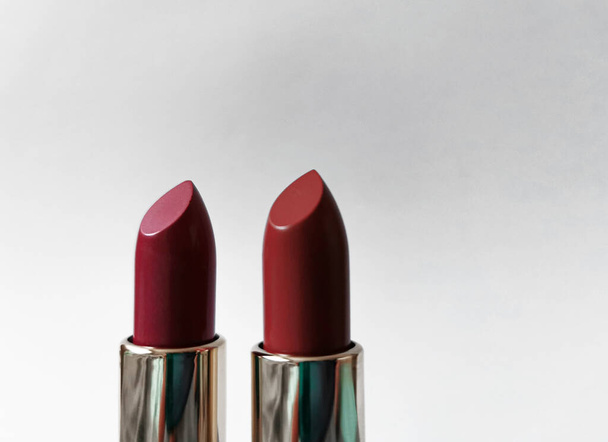 Two red lipsticks on a white background - Foto, afbeelding
