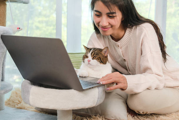 Young Asian woman working from home with her cat at home. - Fotografie, Obrázek