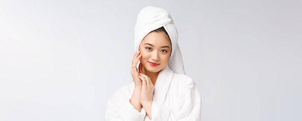 Spa skincare beleza mulher asiática secagem cabelo com toalha na cabeça após o tratamento do chuveiro. Bela menina multirracial tocando pele macia
. - Foto, Imagem