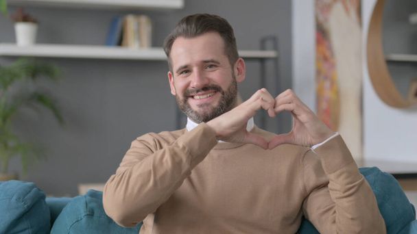 Portret van de mens toont hart teken met de hand - Foto, afbeelding