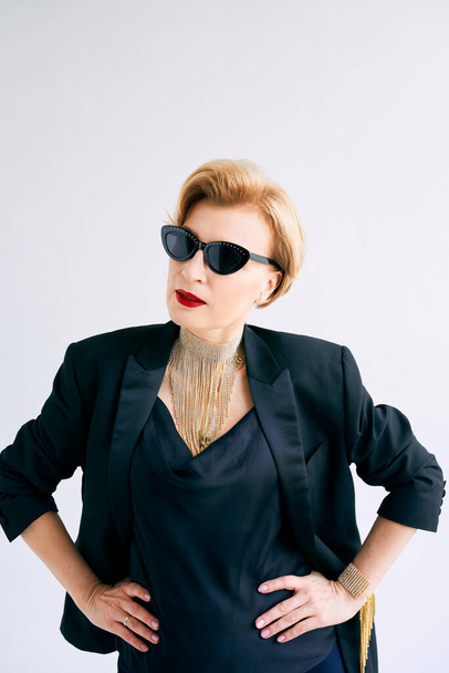 fashionable mature woman in tuxedo and sunglasses. Make up, fashion, anti aging concept - Foto, afbeelding