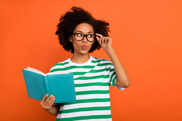 Portrait of attractive funny intellectual wavy-haired girl reading plan touch specs pout lips isolated on bright orange color background - Foto, imagen
