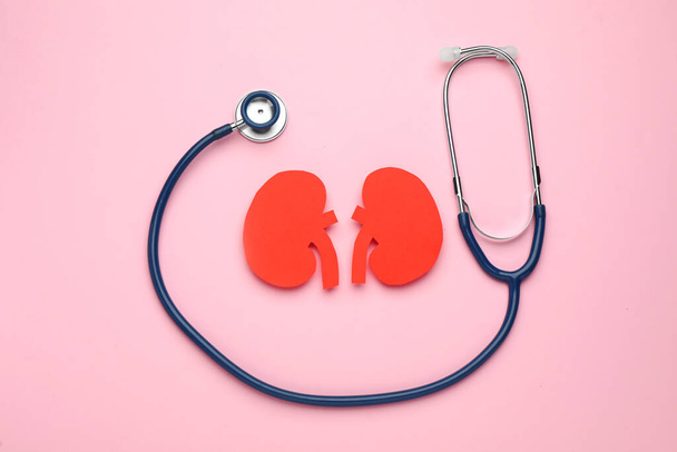 Paper cutout of kidneys and stethoscope on pink background, flat lay - Foto, Imagen