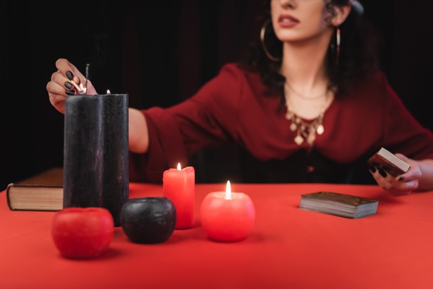 Cropped view of medium burning candles near tarot cards isolated on black  - Foto, Imagem
