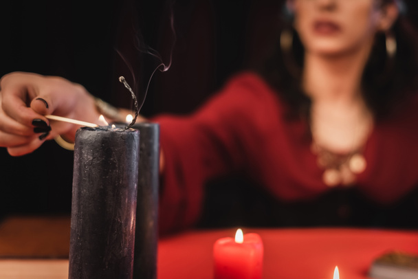 Cropped view of blurred medium burning candle isolated on black  - Фото, изображение