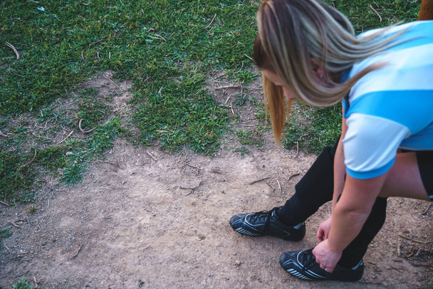 Футболистка, завязывающая шнурки на кроссовки - Фото, изображение