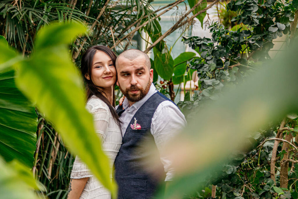 beautiful couple girl and guy in the park among tropical trees close-up - Fotografie, Obrázek