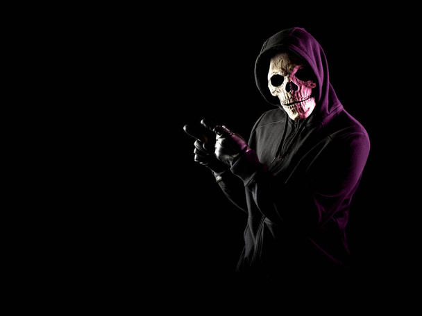 Modern death character on a black background pointing to the left. - Foto, afbeelding