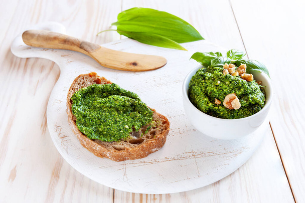 Fresh homemade wild garlic pesto made with Bear Leek herbs, delicious savory sauce for Italian pasta and ingredients for its cooking	 - Foto, Bild