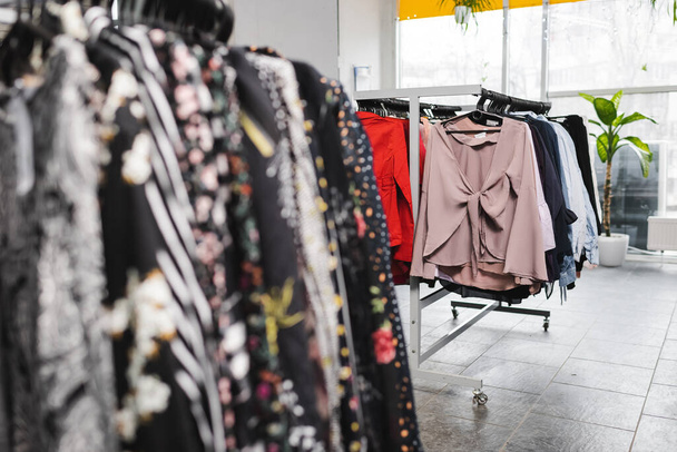Блузки на вішалках в ретро магазині
 - Фото, зображення