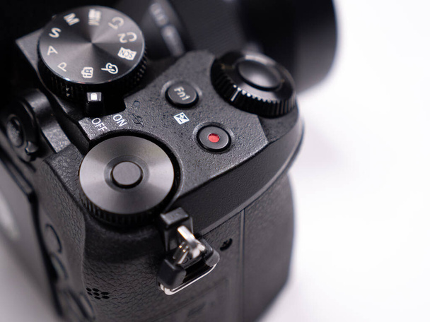 Botones de control y anillos de control en una vista de cerca de la cámara sin espejo sobre un fondo blanco - Foto, Imagen