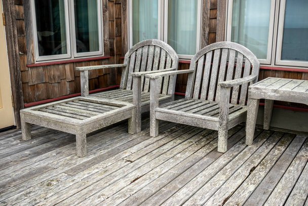 Angled view of wooden deck chairs at a cliffside cabin by the sea in the Pacific Northwest - Photo, Image