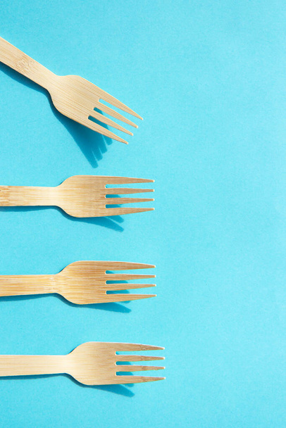 Wooden eco bamboo cutlery on bright blue background - Photo, Image