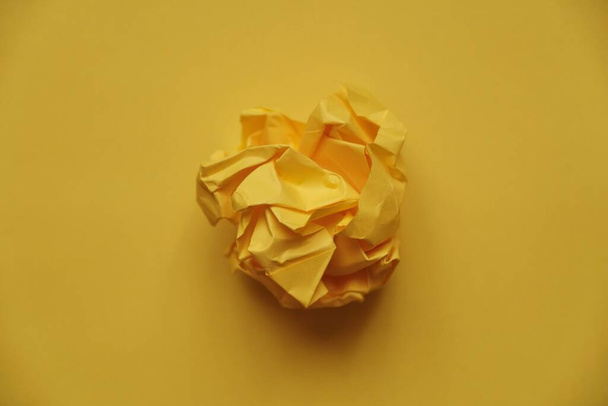 een bolletje verfrommeld gekleurd papier in de vorm van een roos - Foto, afbeelding