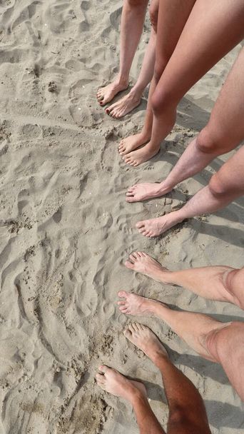 visto desde arriba diez pies en la playa de arena de una familia de cinco personas con padre madre y tres hijos - Foto, Imagen