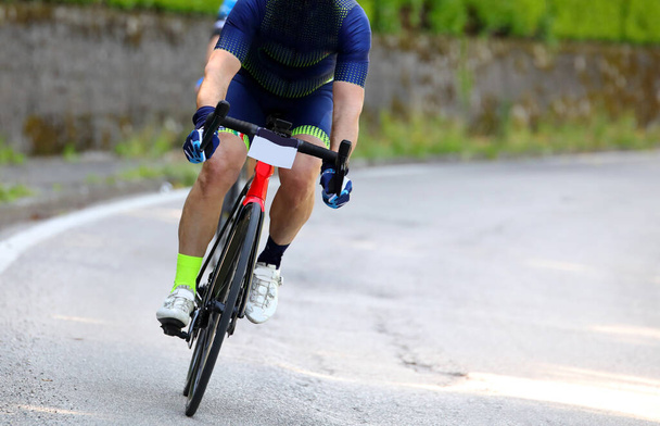 Cyclist on a racing bike engaged in the dangerous curve during the cycling race - Photo, Image