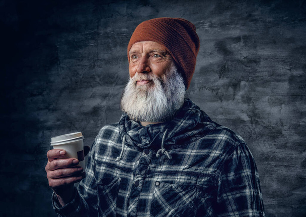 Cabeza de hipster de edad avanzada vestido con camisa a cuadros con taza de café - Foto, imagen