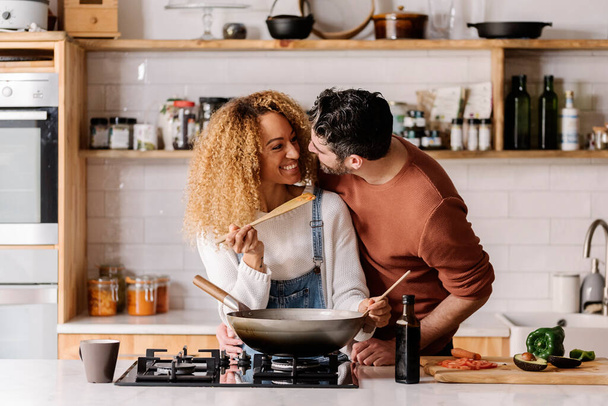 Couple preparing food in kitchen. - Фото, изображение
