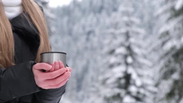 Girl drinking tea in the winter forest, an amazing place with a beautiful snow-covered forest  - Imágenes, Vídeo
