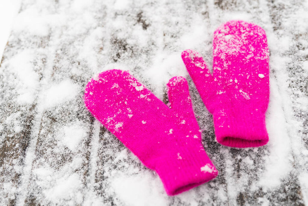 Pink mittens on white snow, top view. Winter outdoor games - Foto, imagen