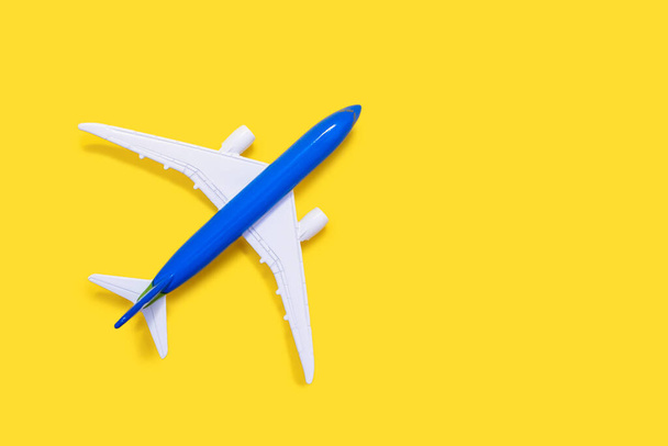 Aircraft model on a yellow background with free space for text or advertising. Tourism or freight transport concept. Toy airplane on a red background with a top view - Photo, Image