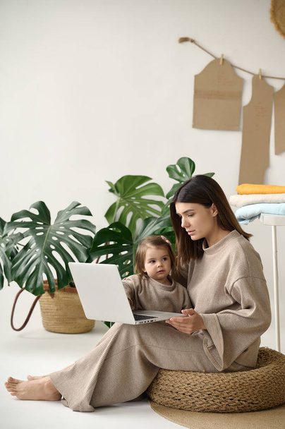 Dressmaker making clothes in her studio with her daughter. - Foto, Imagem