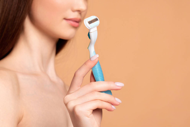 attractive girl holding in hand razor shaver blade i - Zdjęcie, obraz