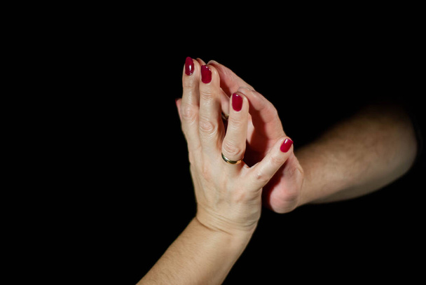 Hands of husband and wife lovingly holding hands while married for many years - Foto, Imagen