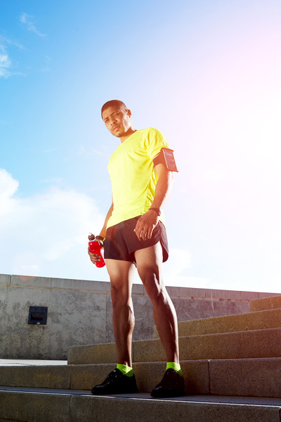 Dark skinned athletic runner with muscular strong body resting after jogging, beautiful fit man in bright fluorescent sportswear, sports fitness concept - Fotó, kép