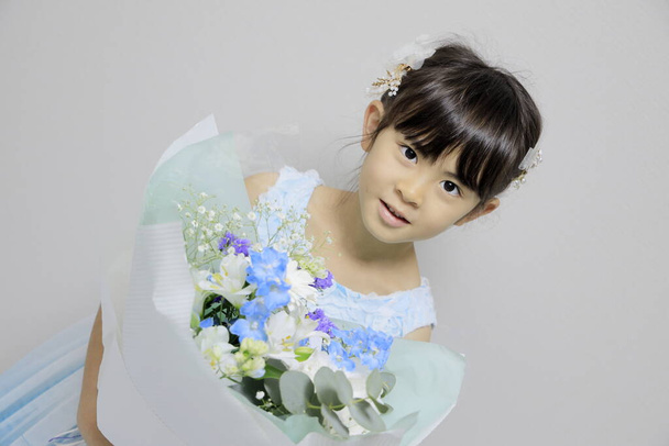 Japanese girl in a dress with bouquet (7 years old) - Фото, зображення