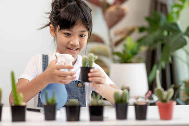 Asyalı küçük kız eve bitki ekiyor. Doğadaki ağaç için anaokulu çocuğu ve çocuk eğitimi için bitki yetiştirme konsepti. - Fotoğraf, Görsel
