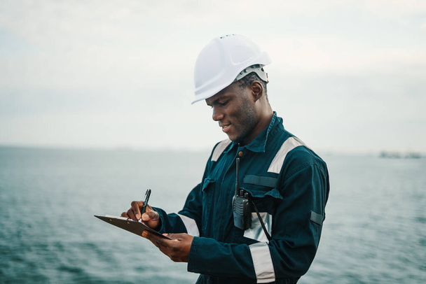 African American seaman filling checklist during work - Foto, Imagem