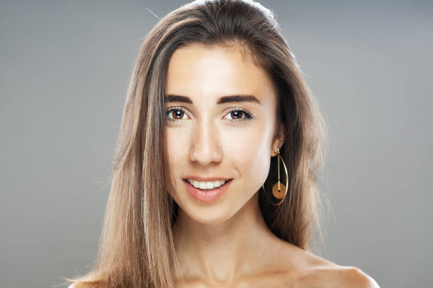 Beautiful brunette girl studio portrait. Smiling face expression. - Foto, afbeelding