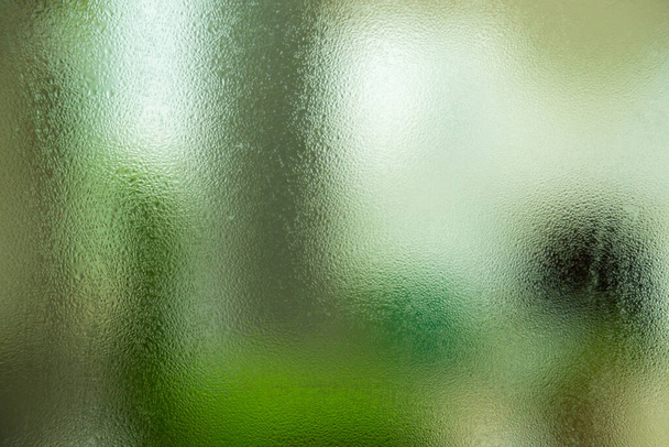 φυσικό πίσω από το υγρό γυαλί με σταγόνες νερού στο γυάλινο φόντο - Φωτογραφία, εικόνα
