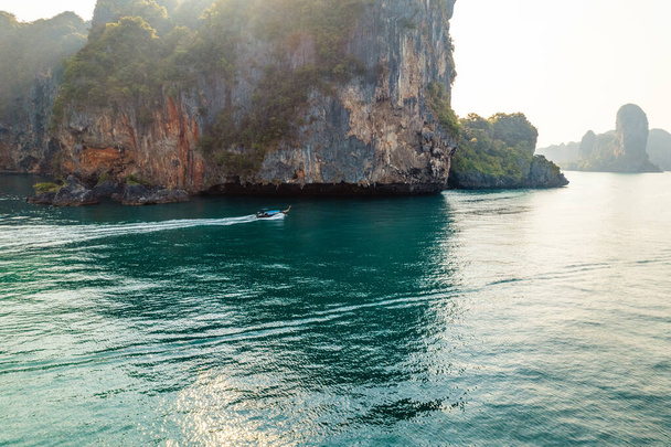 クラビの上に長い尾のボートを持つ海の景色と岩の島  - 写真・画像