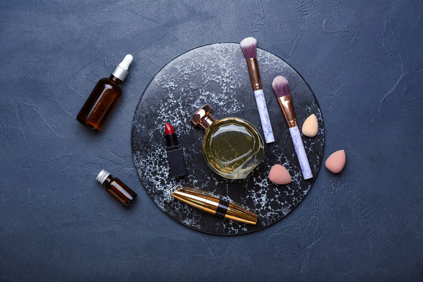 Composition with different cosmetics, makeup brushes and sponges on dark background - Foto, imagen