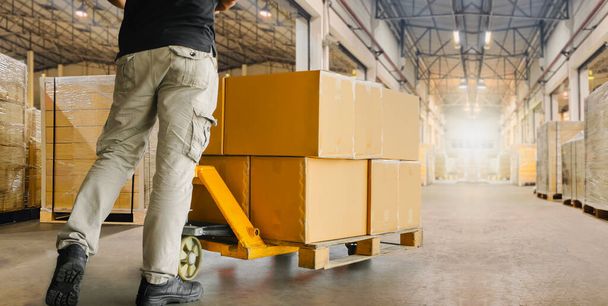 Workers Unloading Packaging Boxes on Pallet in Distribution Warehouse. Cardboard Boxes. Shipping Supplies Warehouse. Shipment Boxes. Storehouse. Cargo Warehouse Logistics. - 写真・画像